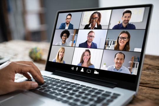 Cropped Image Of Businessman Using Laptop At Desk Review of Video Conferencing Solutions